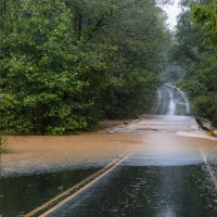 Photo of a road with brown water running across it